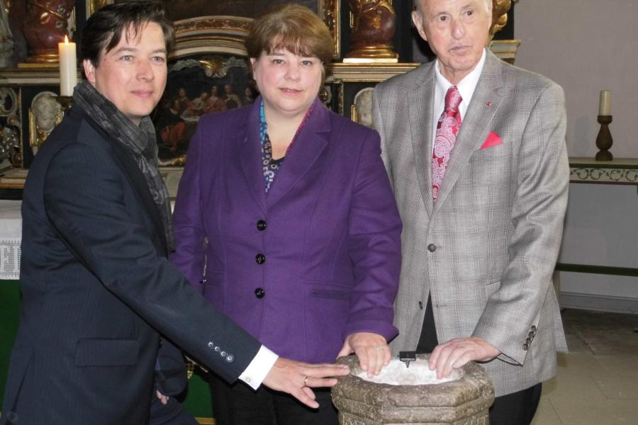 Übergabe: (von links) Prof. Rainer-Maria Weiss (Direktor Archäologisches Museum Hamburg), Pröpstin Carolyn Decke (Propstei Harburg) und Otto Ernst (Spender) bei der Übergabe des Weihwasserbeckens in der St. Maria Magdalena Kirche Moorburg. Copyright Archäologisches Museum Hamburg.