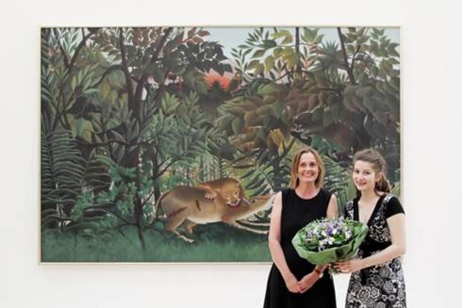 Abbildung: Katrin Meyer (links) mit der Austauschschülerin Héloïse in der Fondation Beyeler vor Henri Rousseau, Le lion ayant faim se jette sur l‘antilope, 1898/1905, Fondation Beyeler, Riehen/Basel, Sammlung Beyeler. Ihr Besuch ist der 7.000.000ste der Fondation Beyeler; Foto: Ana Brankovic