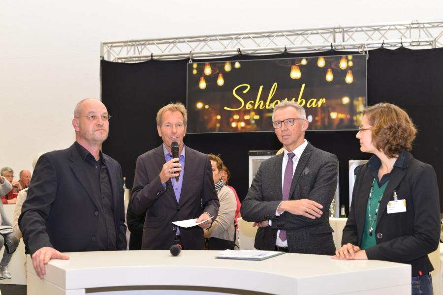 ((Bild Talkrunde; Bildnachweis: Messe Sindelfingen)): Beim Eröffnungstalk (v.l.n.r.): Messechef Ralph Hohenstein, TV-Moderator Markus Brock. Sindelfingens Erster Bürgermeister Christian Gangl und Christin Feilmeier, Unterstützerin des Bildungsprojekts „Artepintura“.