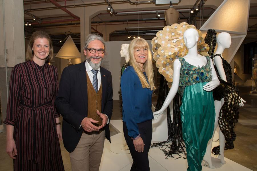 Christa Frins, Martin Schmidt und LWL-Kulturdezernentin Dr. Barbara Rüschoff-Parzinger (v.l.) stellten die Ausstellung "Fashion Material. Modewelten von Stephan Hann" in Bocholt vor. Im Foto die Kreation "Peacock" - ein Kleid aus Pfauenfedern aus Papier und CDs. Foto: LWL/Hudeman