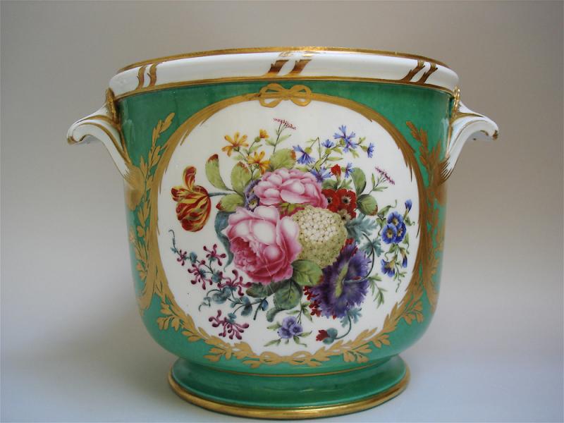 Exhibitor: Michele Beiny  Sèvres bottle cooler from the Emperor Joseph II Service Soft paste porcelain decorated on a green ground with two reserves depicting large panels of exquisitely painted flowers and fruit edged with a distinctive gilding pattern of knotted ribbons, palm fronds, flower and laurel garlands, 18.4 x 26 cm.  Marked with interlaced L's, date-letter 'Y' and painter's mark 'nq' for Nicquet  France, 1776