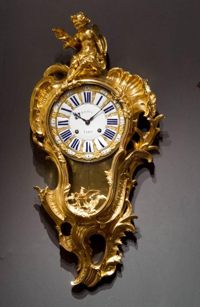 Exhibitor: Richard Redding Antiques Ltd  Julien Le Roy (1686-1759) Louis XV cartel clock Case almost certainly made by Jacques Caffiéri  Gilt bronze, height 95 cm  Signed on the central white enamel dial plaque Julien Le Roy and similarly on the movement, the case stamped with a C-couronné poinçon.  Paris, 1745-49