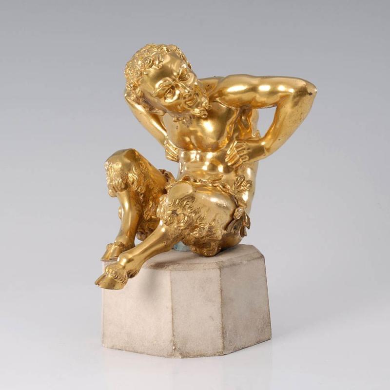 Vergoldete Bronze: Sitzender Faun. Um 1800. Ergänzter 8-eckiger Stein-Sockel. Auf dem Boden sitzender Faun mit Pferdebeinen, der sich vor Lachen krümmt, Limit: 4.200 €