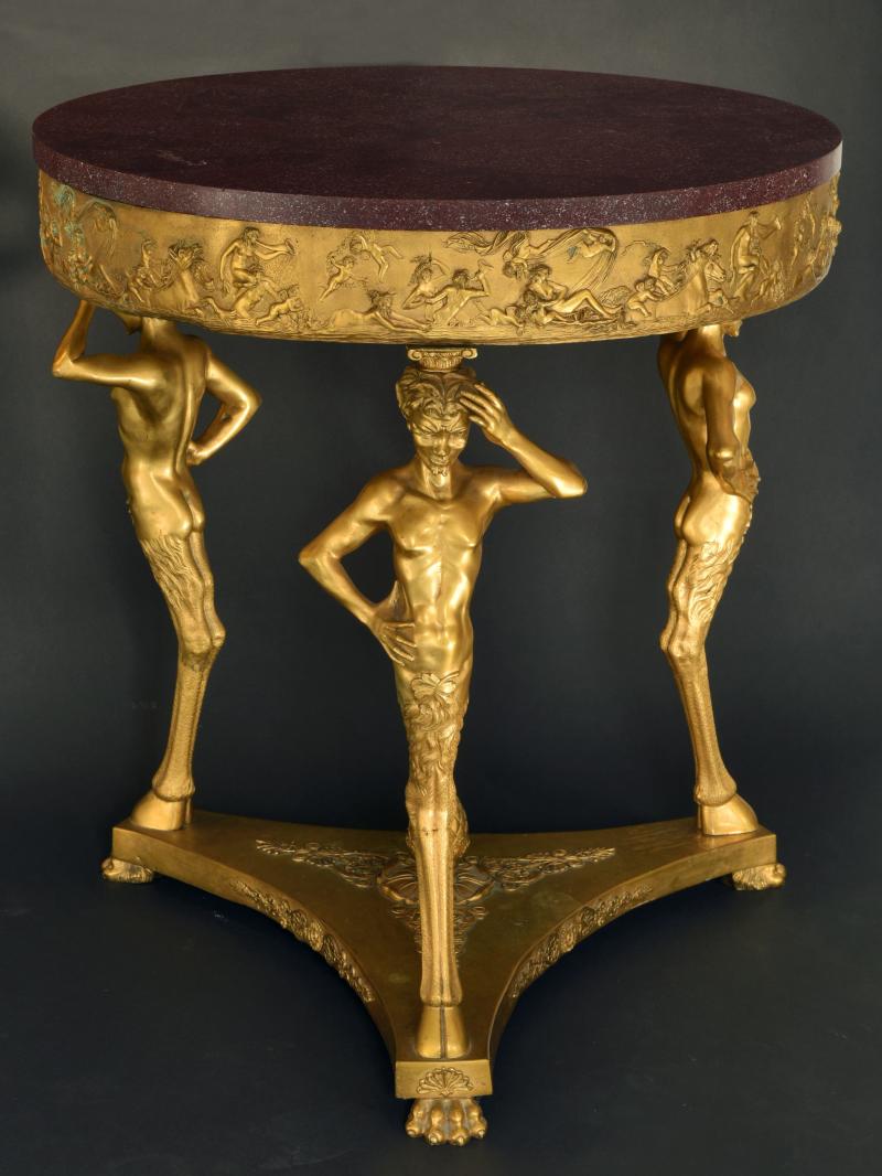 Tisch, Bronze feuervergoldet  Tisch, Bronze feuervergoldet ,  wohl Frankreich um 1820,  H 82cm Durchmesser 74cm,  Platte Porphyr  Kunsthandel Brigitte Martini,  Stand Nr. 23