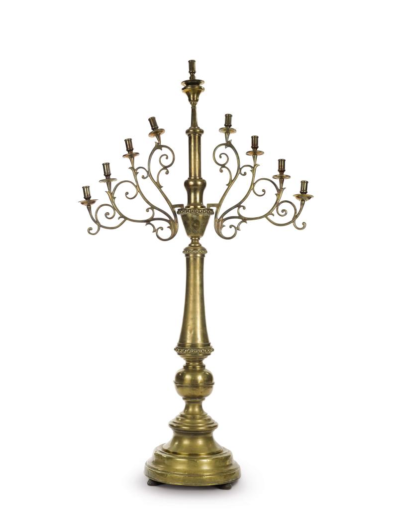 Lot 55 Property From The Estate Of Shlomo Moussaieff Monumental Polish brass synagogue Hanukah lamp, circa 1890 baluster stem with large beaded borders, engine-turned panels, scrolling arms. height 72 in. 183 cm Est. $30/50,000