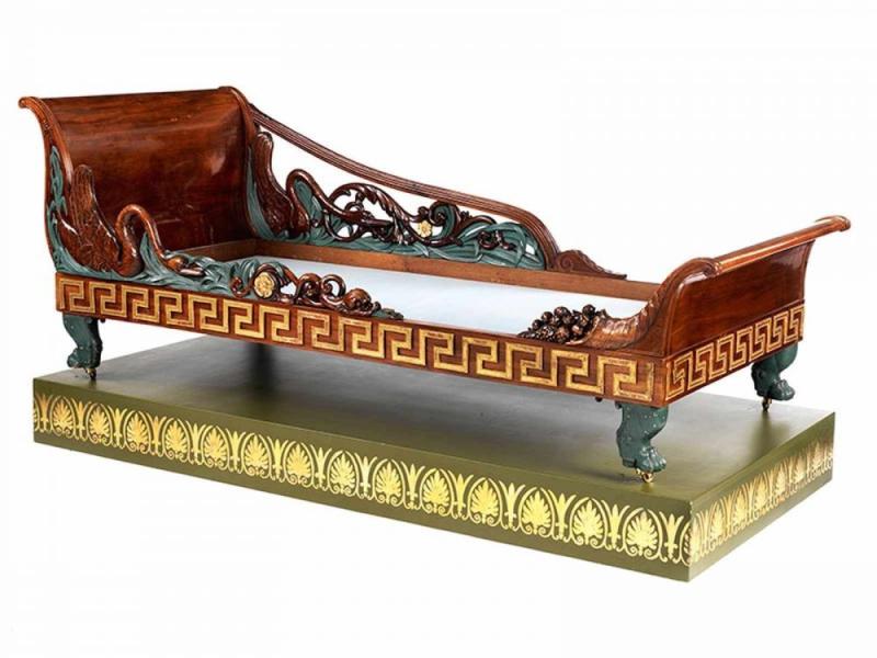 Seltenes Empire-Bett mit Schwanendekor Höhe: 83 cm. Breite: ca. 91,5 cm. Länge: ca. 220 cm. Russland, um 1803. Furniert in Mahagoni sowie Mahagoni, geschnitzt. Schätzpreis:	30.000 - 50.000 EUR