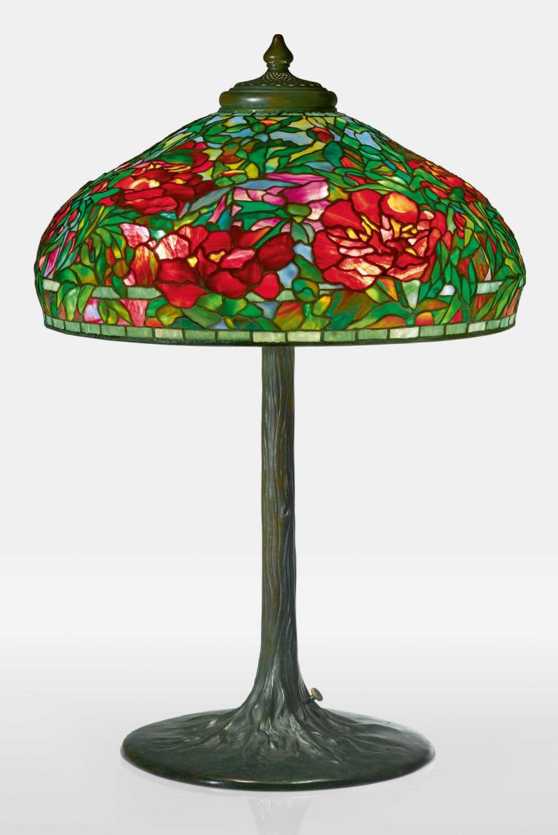 Lot 311 Tiffany Studios "Elaborate Peony” Table Lamp with a "Tree" base shade impressed TIFFANY STUDIOS NEW YORK 1903 base impressed TIFFANY STUDIOS/NEW YORK/553 leaded glass and patinated bronze 33 in. (83.8 cm) high 22 1/4  in. (56.5 cm) diameter of shade circa 1910 Estimate $350/500,000