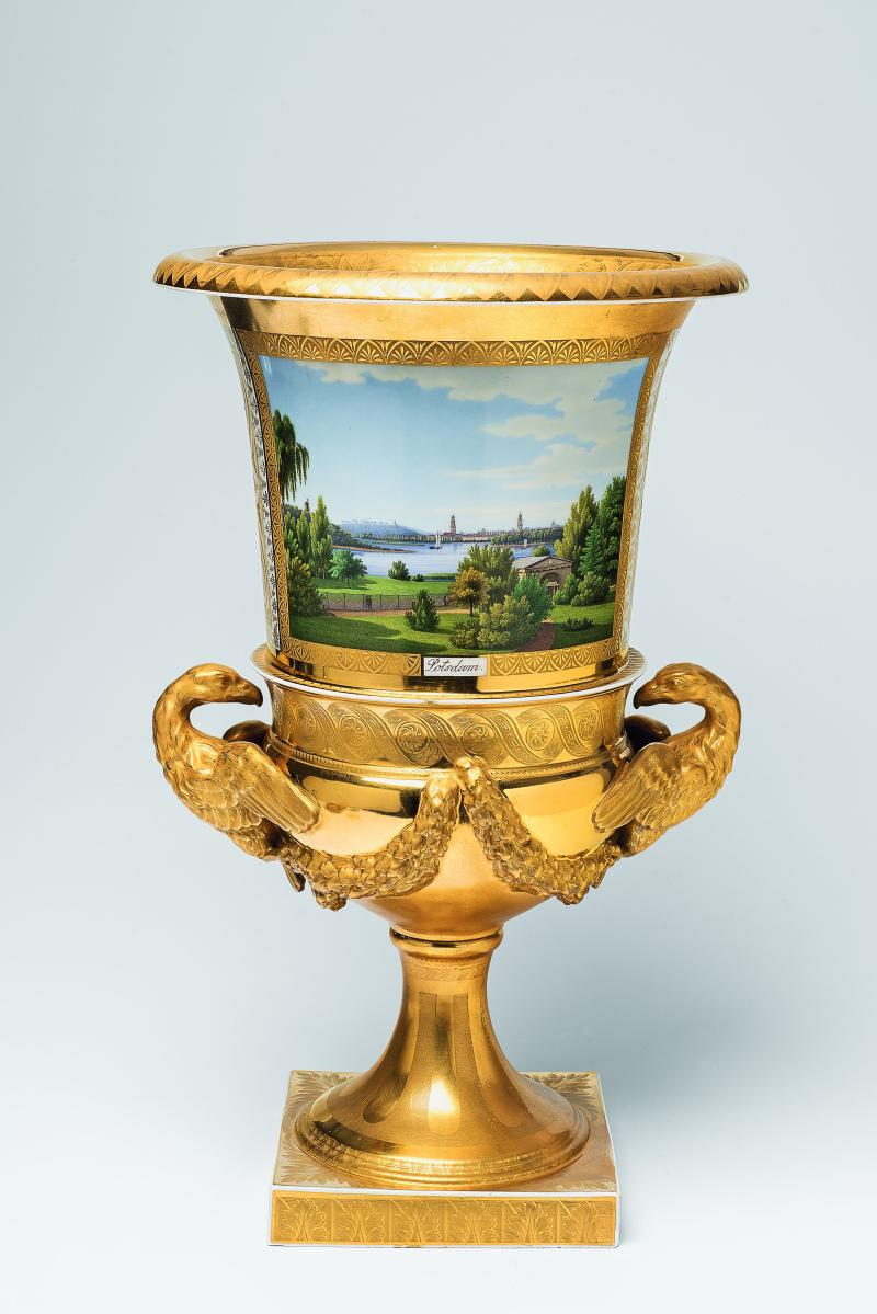 Adlerhenkel-Vase mit Ansichten von Berlin und Potsdam Berlin, KPM, 1825 - 32.  Der Dekor Johann Eusebius Anton Forst zugeschrieben. Porzellan, Emaildekor, chamoisfarbene Fondfelder, radierte matte und glänzende Vergoldung. Blaumarke Zepter, braune Reichsadlermarke, Malerzeichen  Planetenmarke Venus. Schaft restauriert. H 48,5, D 29,5 cm.  Schätzpreis: 30.000 - 40.000 Euro.