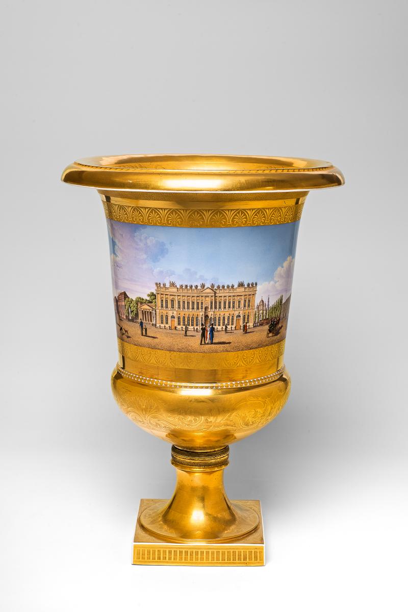 Kratervase mit Panorama Unter den Linden. Berlin, KPM, 1830.  Der Dekor Eduard Wilhelm Forst zugeschrieben, die Bronze von Werner und Mieth, Berlin. Porzellan, Goldfond mit matten und glänzenden Partien, radiertem Dekor, Emailbemalung, vergoldete Bronzemontierung auf Holzkern, mit Stoff unterlegt. Blaumarke Zepter, braune Reichsadlermarke,  Malerzeichen. H 49,2 cm.  Schätzpreis: 60.000 – 80.000 Euro.