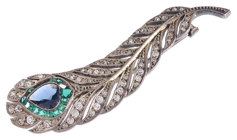 An Art Deco stylish silver brooch in the form of a peacock feather, £50-60.