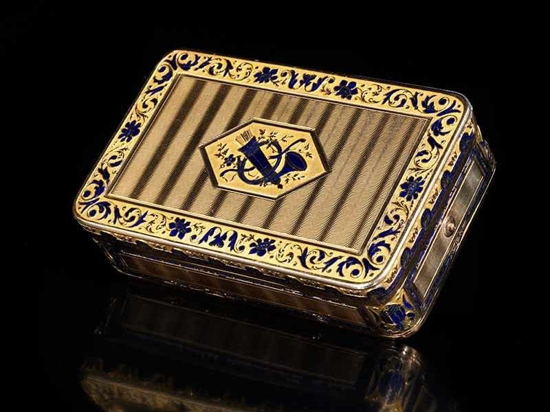 Golddose mit Spielwerk 2,3 x 8 x 4,8 cm. Gewicht: 212 g. Keine für uns sichtbaren Goldpunzen, Deckel innenwandig mit Punze SC. Wohl zweite Hälfte 18. Jahrhundert.  Schätzpreis:	20.000 - 25.000 EUR