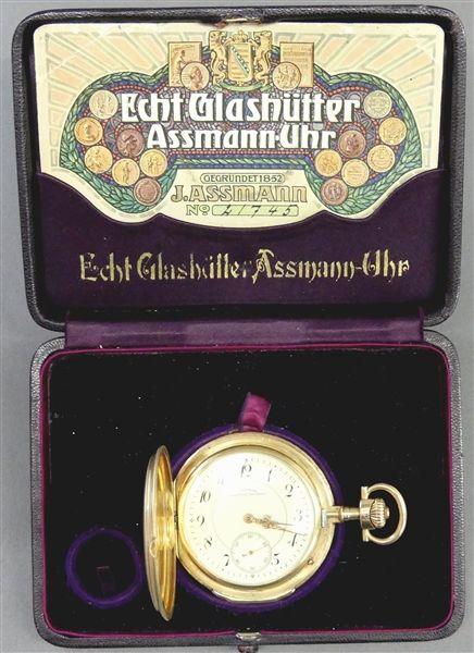 Sprungdeckeltaschenuhr  14 kt. Gelbgold, "I. Assman, Glashütte in Sachsen", Kronenaufzug, Schwanenhalsregulierung, Werk- und Gehäusenummer 21745, Staubdeckel in Gold, Zifferblatt mit arabischen Zahlen, dezentrale Sekunde, mit Originalgarantie-Karte und Etui, läuft an, ca 118g, d 55 mm, Mindestpreis:	3.600 EUR