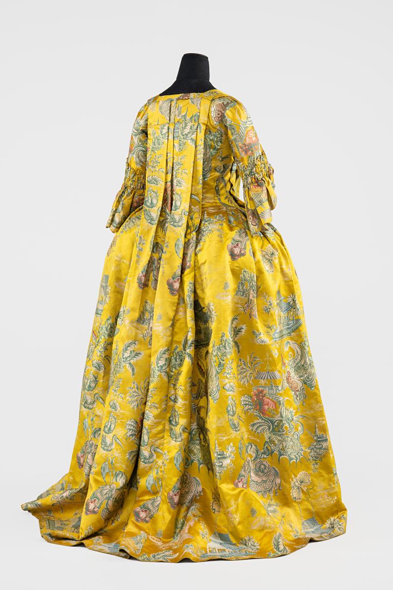 Exotische Seide  Dieser Manteau aus Schweizer Besitz zeichnet sich durch das elaborierte Seidengewebe mit Chinoiserie-Dekor aus. Der Stoff stammt aus den Niederlanden, wo Fabrikanten sich auf Gewebe mit fernöstlich inspirierten Mustern spezialisieren und diese nach ganz Europa exportieren. Manteau, 1730–1750, Seide.  Schweizerisches Nationalmuseum